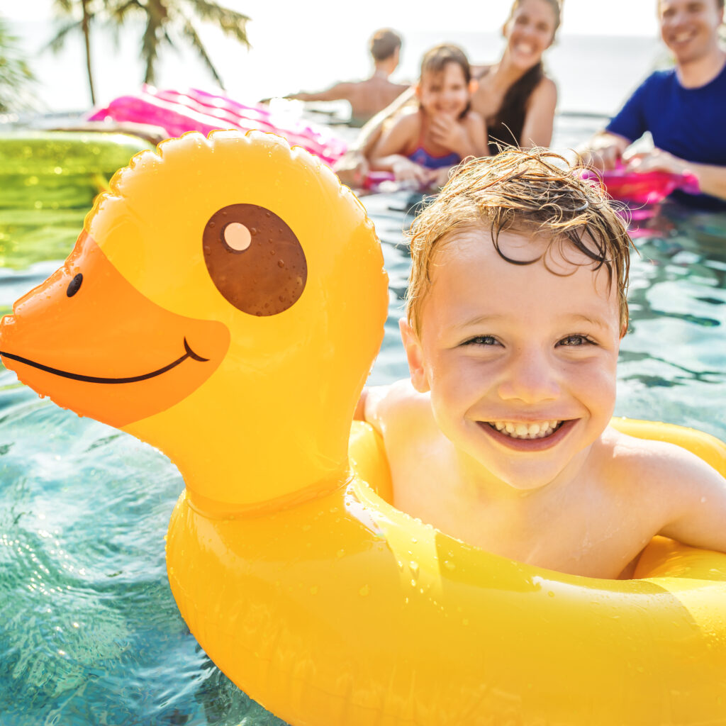 boy swimming in a pool with family