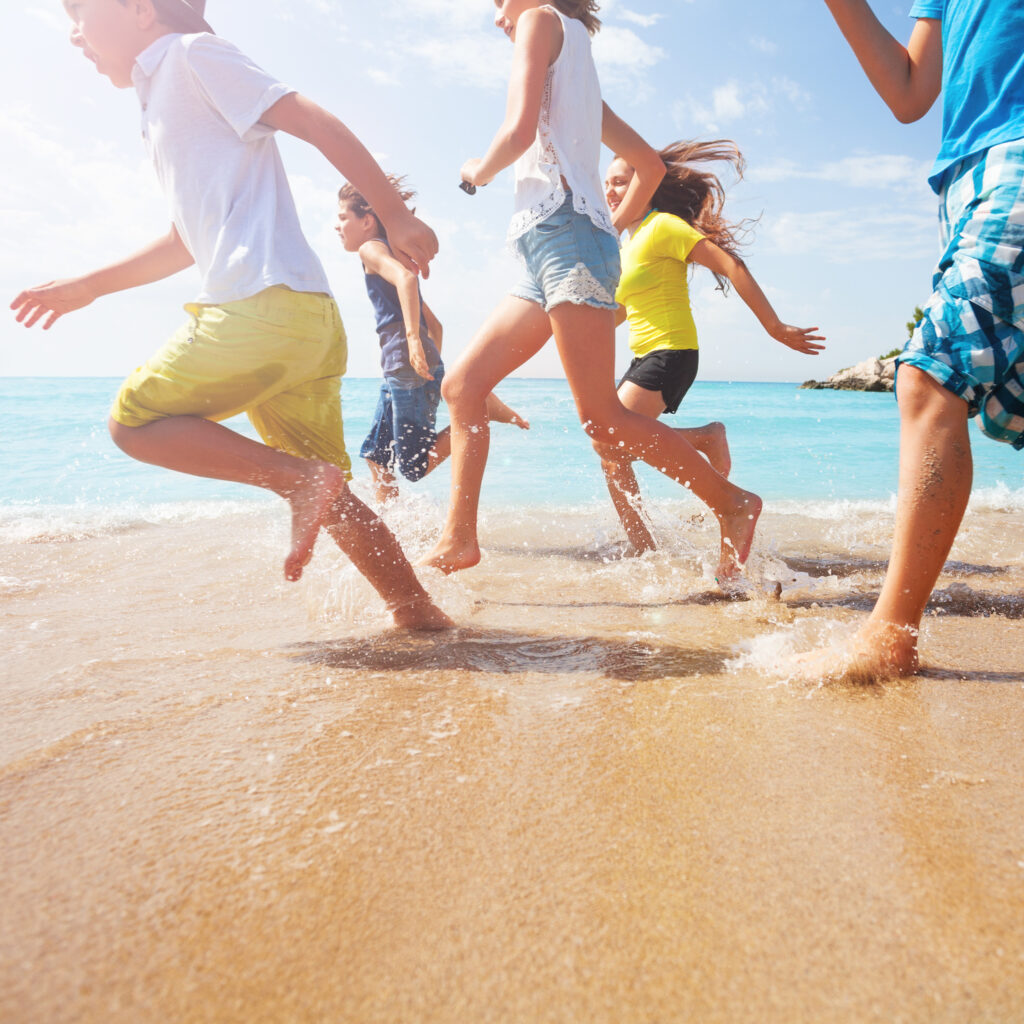 close up of running kids legs in shallow sea water